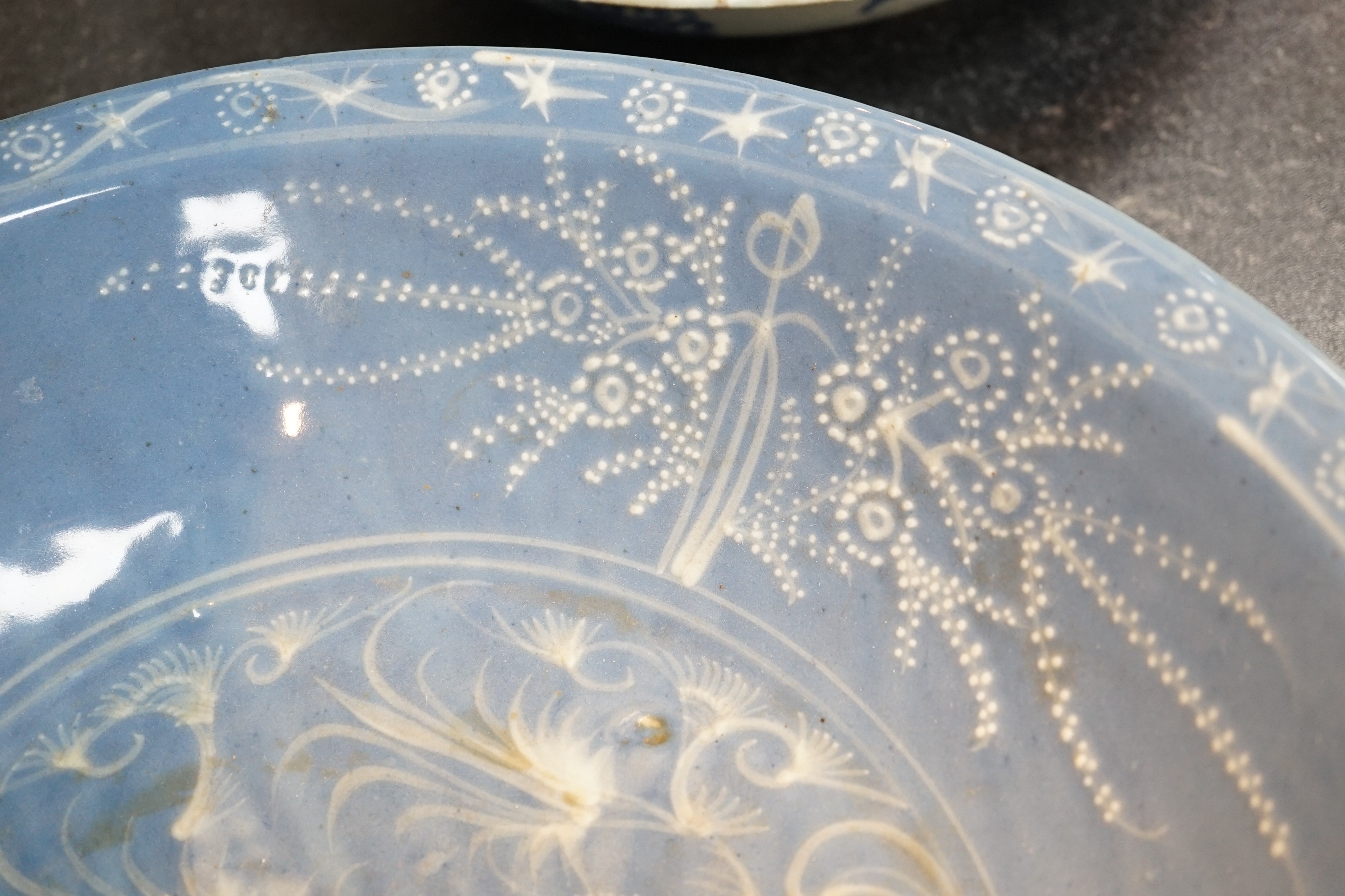 A Chinese Swatow slip-decorated blue glazed deep dish, Zhangzhou kilns, early 17th century, 38cm wide, crack to base